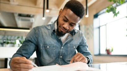 Jeune professionnel ivoirien rédigeant une lettre de motivation personnalisée.