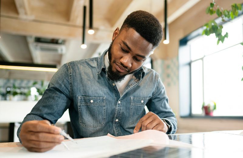Jeune professionnel ivoirien rédigeant une lettre de motivation personnalisée.