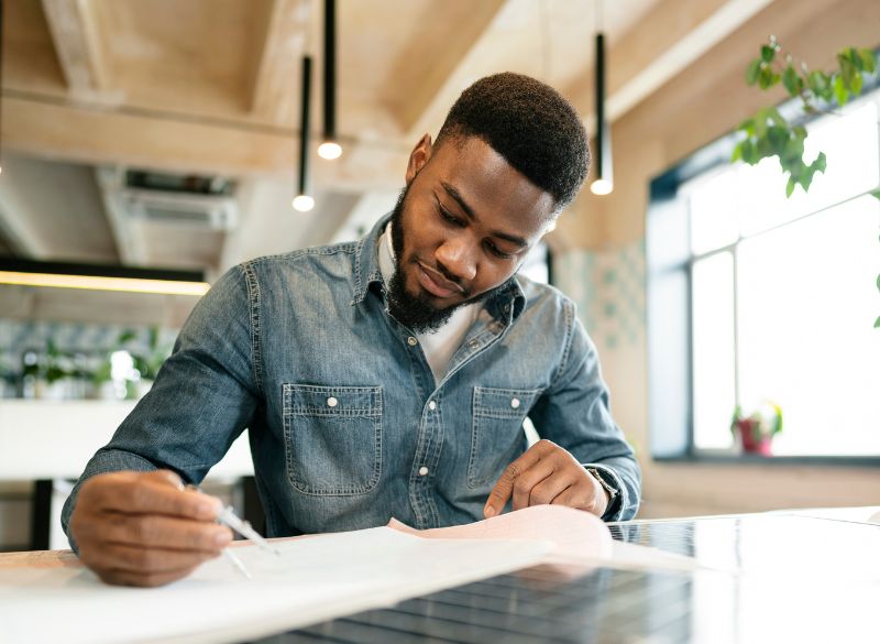 Jeune professionnel ivoirien rédigeant une lettre de motivation personnalisée.